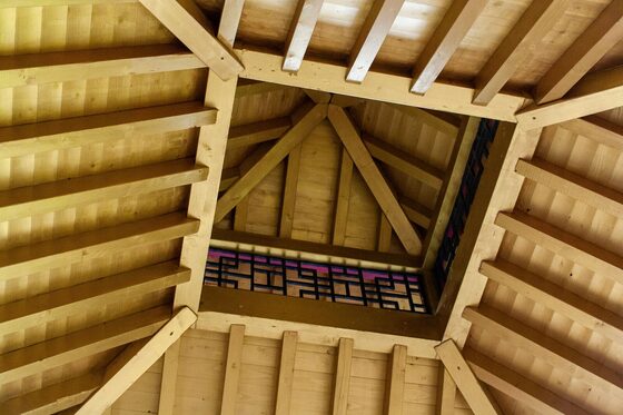 Charpente traditionnelle en bois d'une toiture à quatre pans, vue de l'intérieur